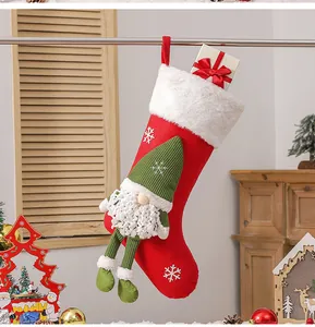 Détail d'une chaussette de Noël rouge avec gnome en tricot et jambes en peluche suspendue