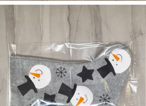 Flat lay of gray Christmas stocking with snowman and snowflake prints in packaging