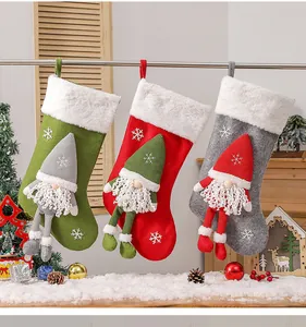 Détail de trois chaussettes de Noël tricotées avec gnomes 3D et flocons de neige
