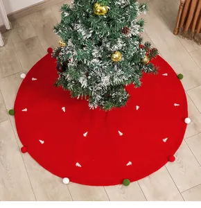 Close-up of red felt Christmas tree skirt with white tree embroidery and colorful pompoms