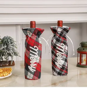 Detalle de fundas de botellas de vino a cuadros rojos y verdes con bordado Merry de Navidad
