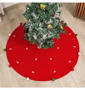 Detail of red Christmas tree skirt with white tree embroidery and colorful pompoms