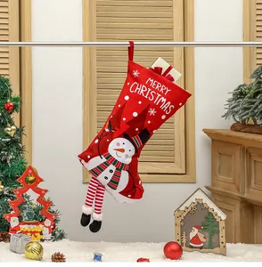 Detail of red Christmas stocking with snowman design and long striped legs for tree decor