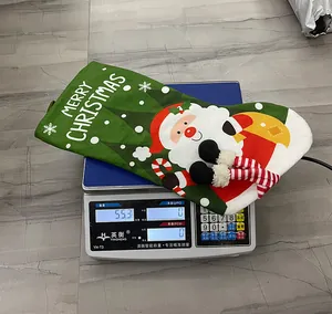 Close-up of green Christmas stocking decoration on an electronic scale weighing 55.3g