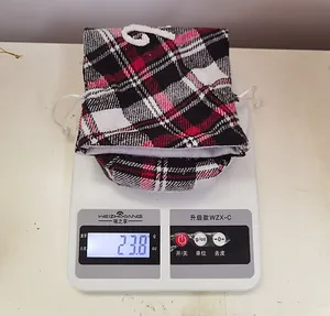 Detalle de bolsa de tela de cuadros rojos de 23,8 g sobre una báscula digital