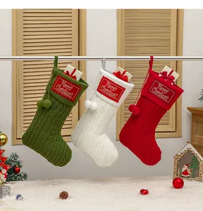 Detail van gebreide kerstsokken met kabelpatroon en Merry Christmas borduursel