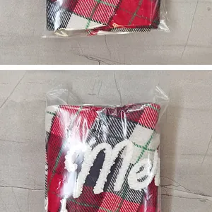 Detalle de tela escocesa roja y verde con bordado de felpa de Feliz Navidad