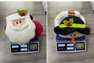 Detailed scale view showing the weight of Santa and Snowman plush Christmas tree toppers