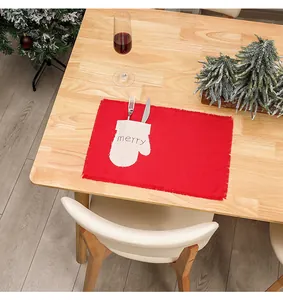 Detail of red Christmas placemat with a merry glove pocket for festive cutlery storage
