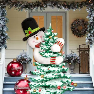 Snowman tree hugger with long striped arms on a snowy Christmas tree with ornaments