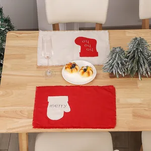 Linen Christmas placemats featuring red mittens and festive stockings on a wooden table