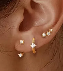 Gros plan sur un ensemble de boucles d'oreilles en laiton doré avec étoiles en zircon