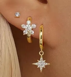 Vue détaillée de l'ensemble de trois boucles d'oreilles dorées avec pendentifs fleur et étoile