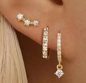Vue détaillée de l'ensemble de trois boucles d'oreilles dorées avec étoiles et zircons
