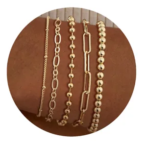 Set de cinco pulseras de latón bañadas en oro con diversos eslabones para mujer
