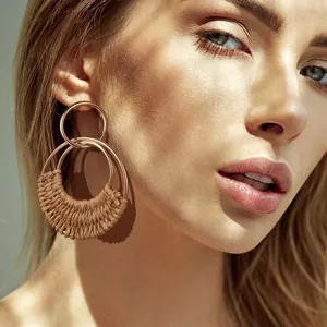 Bohemian gold-plated hoop earrings featuring handcrafted raffia weave and metal circles