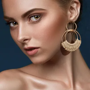 Bohemian gold plated hoop earrings with handmade cream rattan weaving on female model