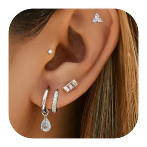 Ensemble de boucles d'oreilles dorées avec clous en cristal et créoles sur un modèle