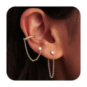 Dettaglio del set di ear cuff dorati con zirconi brillanti e sottili catene di collegamento