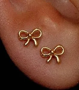 Nahaufnahme von goldenem Schleifen-Ohrstecker am Ohr mit minimalistischem Design