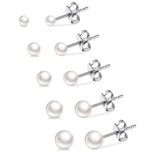 Detail shot of five pairs of graduated white pearl stud earrings on silver posts