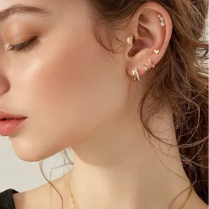 Set di orecchini eleganti in ottone dorato con cuore e luna su una modella