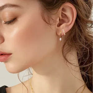 Set orecchini in ottone placcato oro con pendente di perle ed ear cuff indossati sul modello