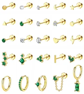 Detalle de set de pendientes dorados con perlas, circonitas verdes y dijes geométricos