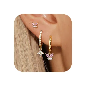 Close-up of gold brass butterfly earrings set with zircon stones on model's ear