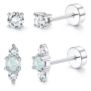 Detail of silver stud earrings featuring round cubic zirconia and opal stones