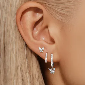 Silver brass butterfly earrings set with sparkling cubic zirconia on model's ear