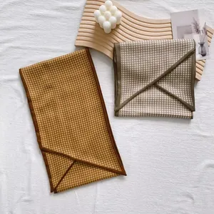 Detail of vintage houndstooth silk scarves on a wooden tray with elegant home decor props