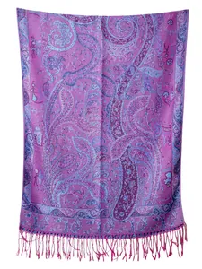 Dettaglio macro della trama jacquard paisley e frange sulla sciarpa pashmina viola
