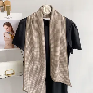 Detail showing elegant houndstooth silk scarf tied on a black dress mannequin neck