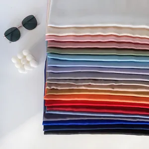 Eleganti scialli in seta a tinta unita in vari colori con occhiali da sole e decorazioni