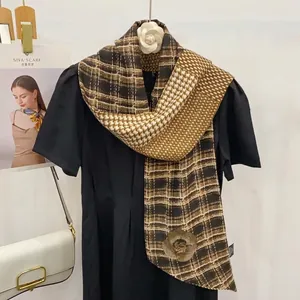 Écharpe à carreaux marron avec motif camélia sur une robe noire pour un look élégant