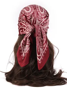 Detail of silk-like paisley square scarf in burgundy tied on long hair from the back view
