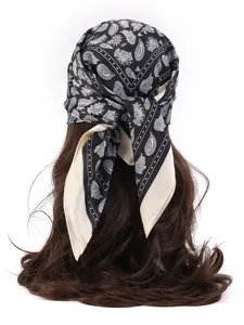 Detail of silk-like paisley bandana in black and cream tied on long brown hair