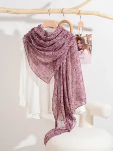 Detail shot of lightweight floral silk scarf draped over a white shirt for elegant styling