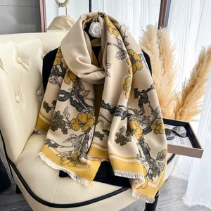 Dettaglio della trama della sciarpa pashmina floreale con fiori gialli e piccole frange