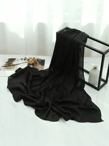 Dettaglio dello scialle nero in chiffon plissettato con trama verticale e morbido
