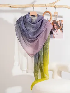 Dettaglio di una pashmina sottile sfumata con motivo paisley nei toni viola e giallo