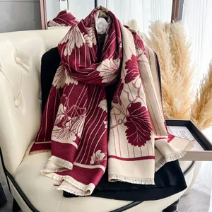 Dettaglio della sciarpa jacquard floreale rosso scuro e beige con frange eleganti