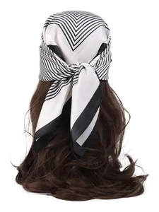 Detailed back view of a black and white geometric silk scarf tied as a hair accessory