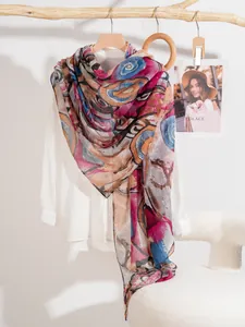 Detail of colorful abstract print silk scarf on wooden hanger with natural lighting