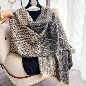 Dettaglio di motivo geometrico e frange corte su scialle in finta cashmere beige