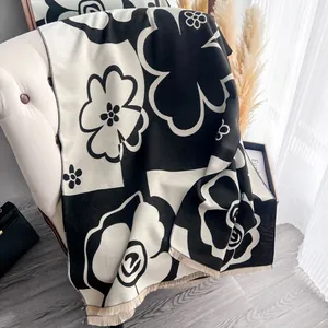 Winter camellia cashmere feel scarf with black white floral print and fringe detail