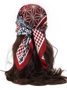 Detail of silk-like printed headscarf with floral and geometric patterns on hair