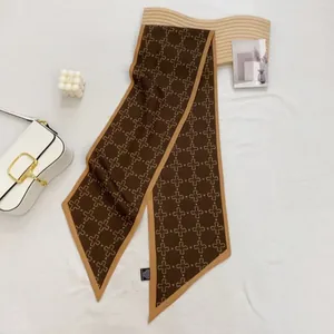 Detail of coffee brown satin twilly scarf with beige floral pattern and contrast piping