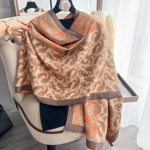 Dettaglio della sciarpa vintage con motivo paisley in tessuto morbido e frange fini